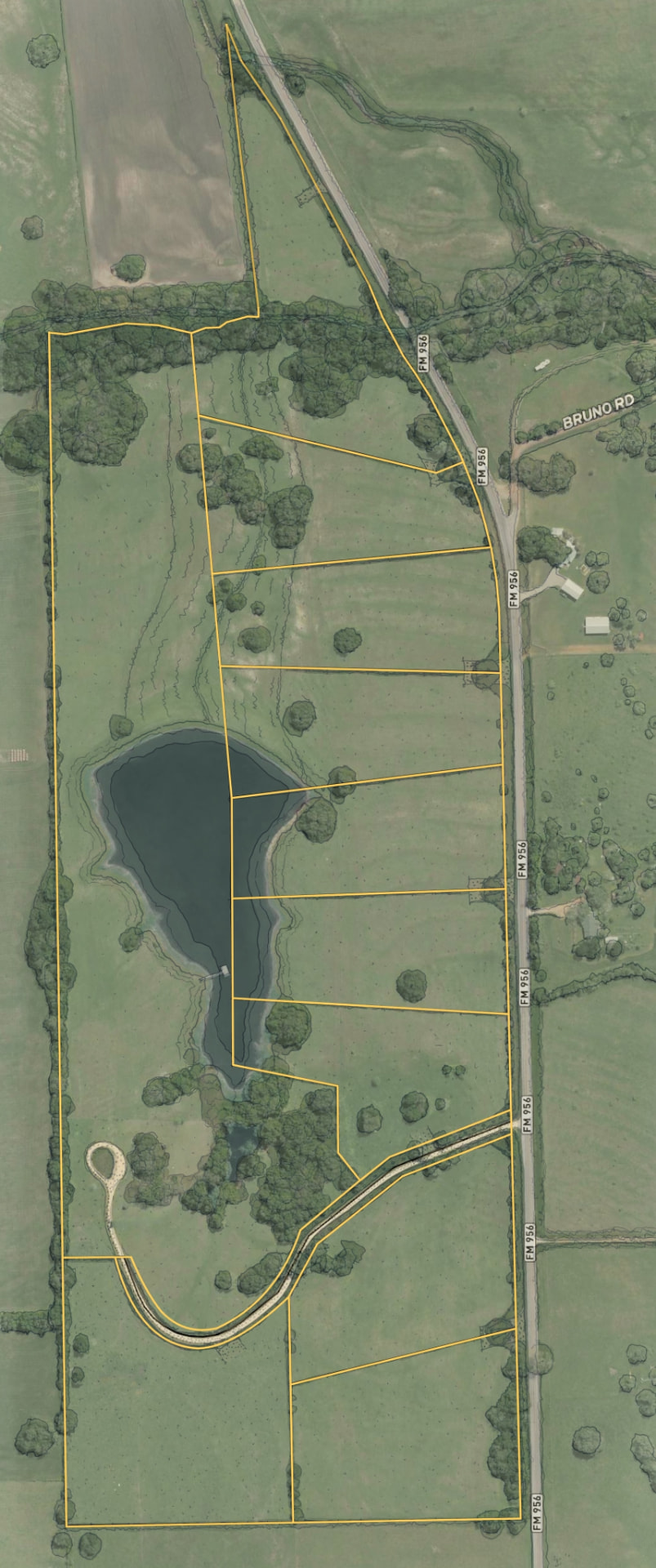 Aerial photograph of the eighty-eight acres at Walker Branch, with FM 956 running along the southern edge, two ponds, and the wooded creek corridor.